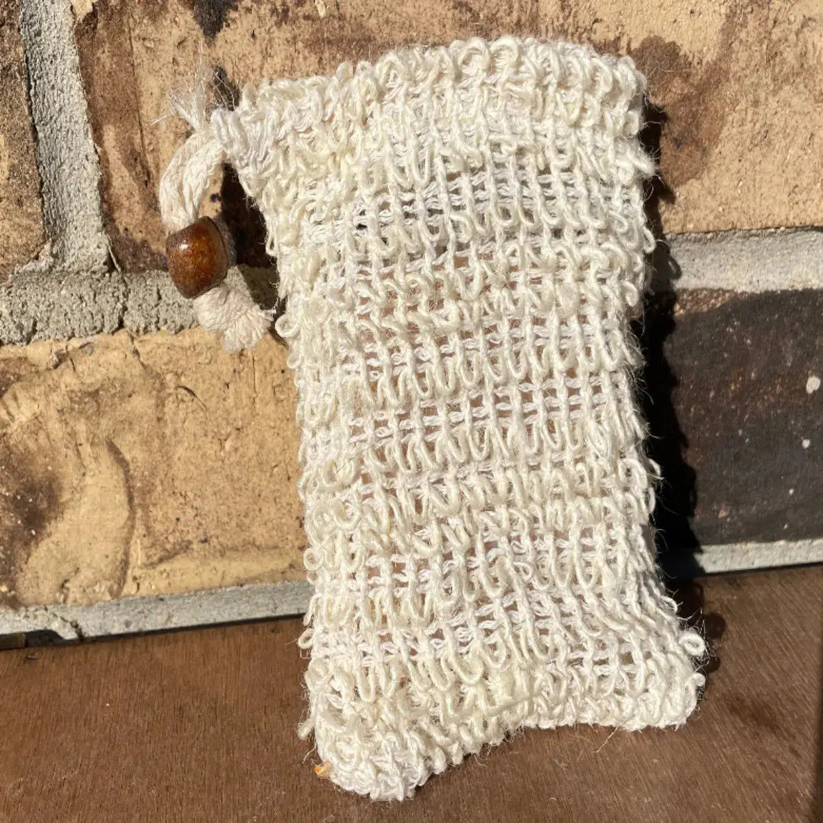 Sisal soap saver pouch with drawstring and wooden bead, 3.5 × 5.5 in, sized for standard bars.