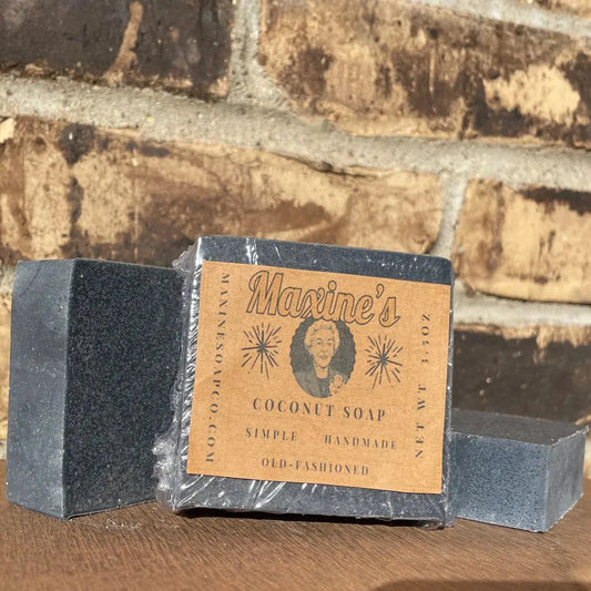 Front of wrapped Coconut Oil Charcoal Bar Soap by Maxine’s, 3.5 oz (99 g), label with ingredients and net weight.